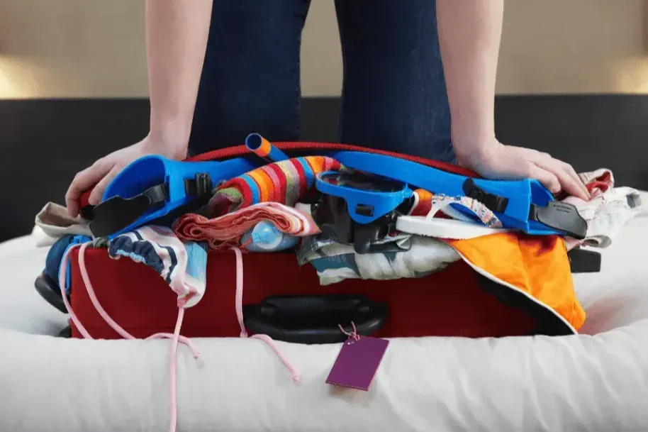 Kneeling On Overstuffed Suitcase