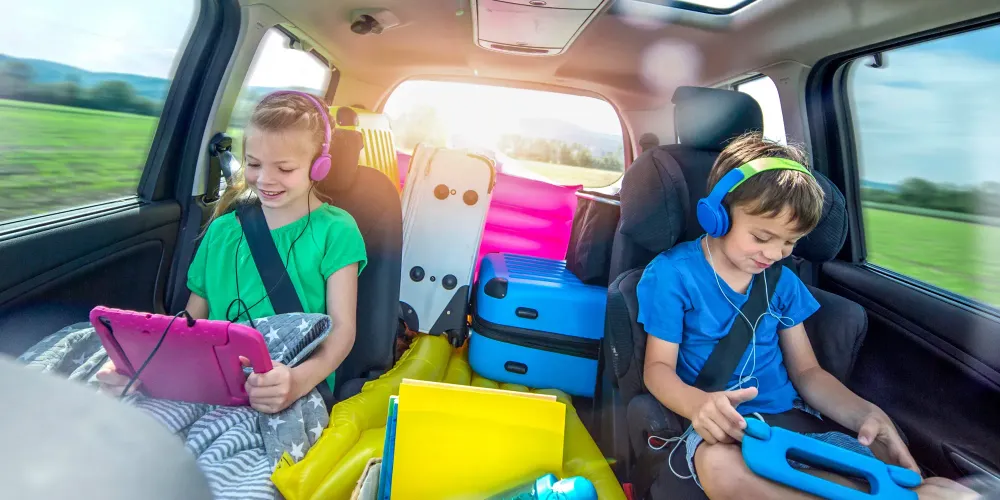 kids in the backseat car roadtrip with gadgets