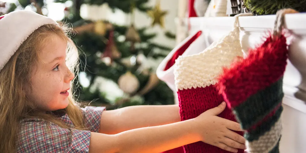 girl holding christmas stocking; Courtesy of Rawpixel/Shutterstock