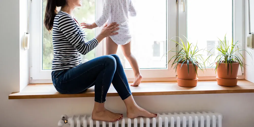 Mother with her little daughter looking out of window; Courtesy of halfpoint/Shutterstock