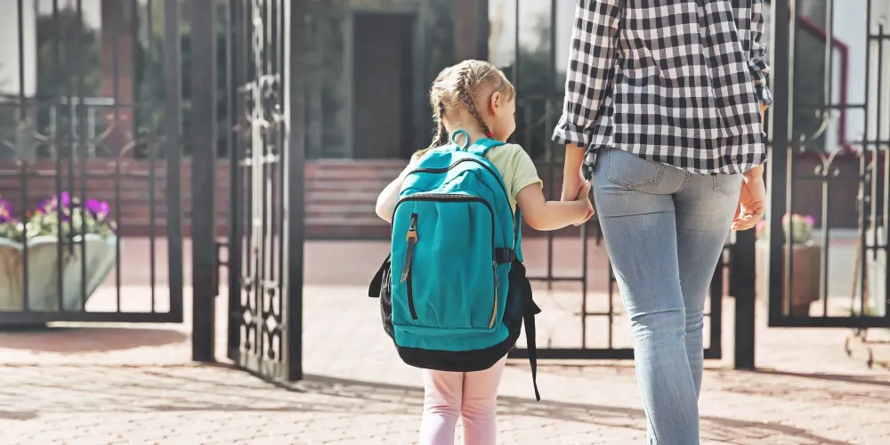 Mother taking daughter to schoo; Courtesy of Africa Studio/Shutterstock