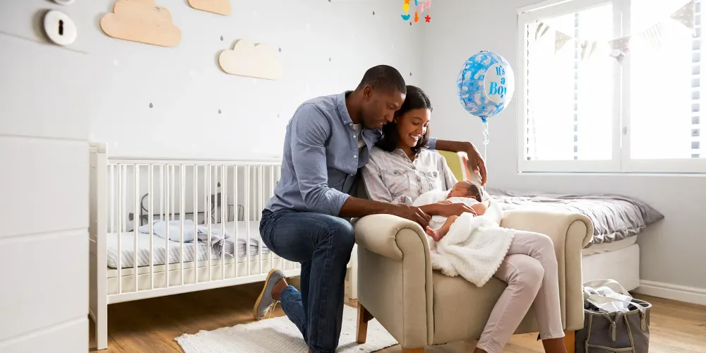 parents holding newborn in baby room; Courtesy Monkey Business Images/Shutterstock