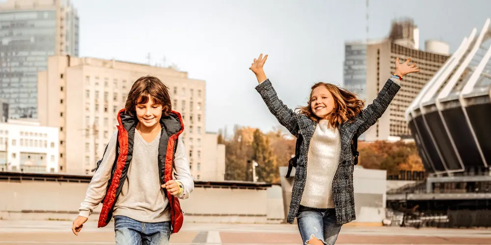 two kids running wearing fall jackets; Courtesy of By YAKOBCHUK VIACHESLAV/Shutterstock