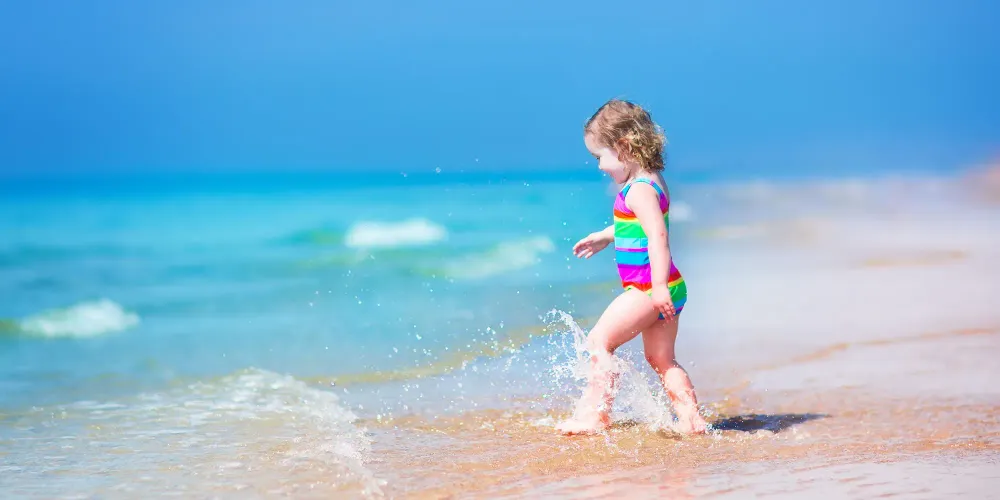 Toddler on the Beach; Courtesy of FamVeld/Shutterstock.com