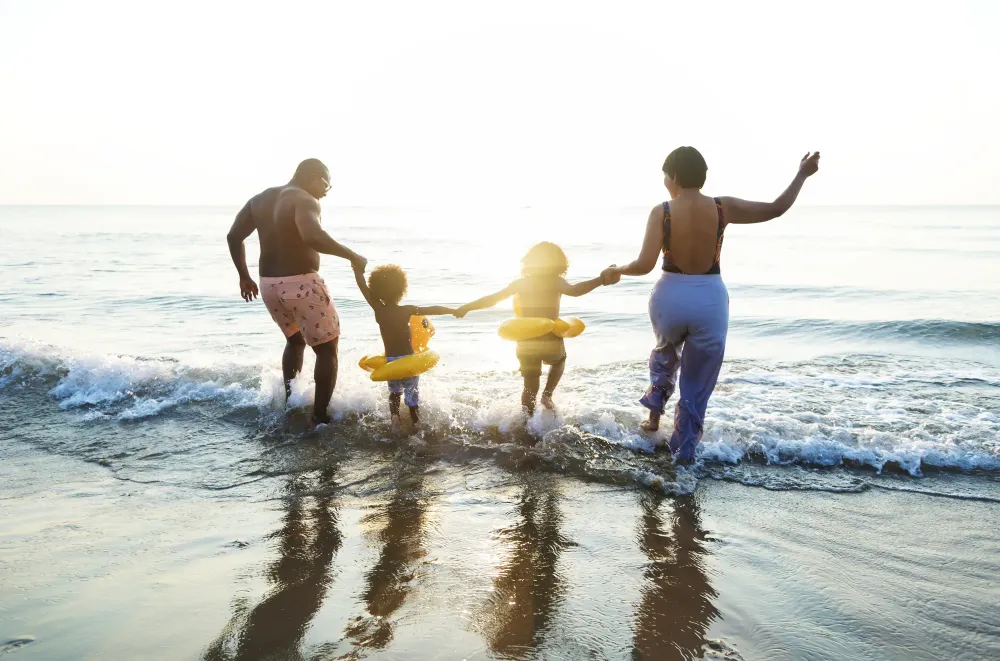 Family jumping into waves on the beach