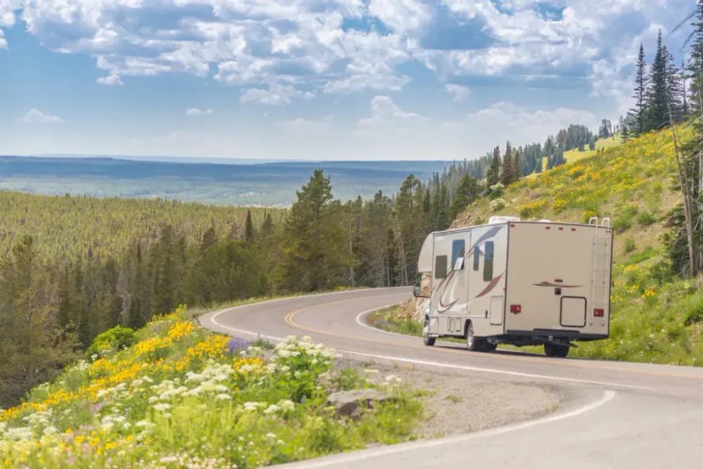 Camper Driving Down Road in green mountains