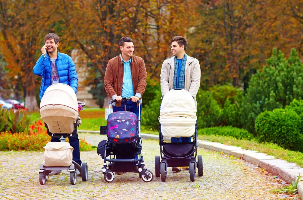 Three fathers walking in the park with strollers