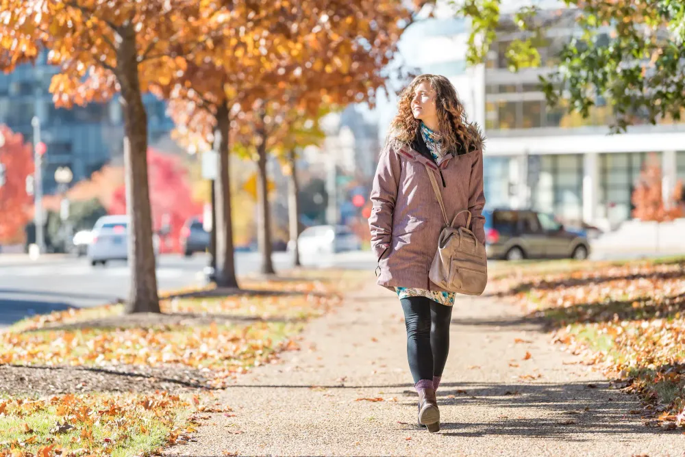 Woman walking down street in autumn