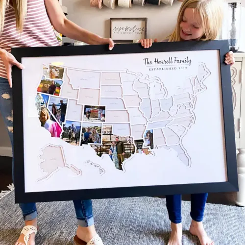 Mother and child holding a large framed map of the United States made from family photos