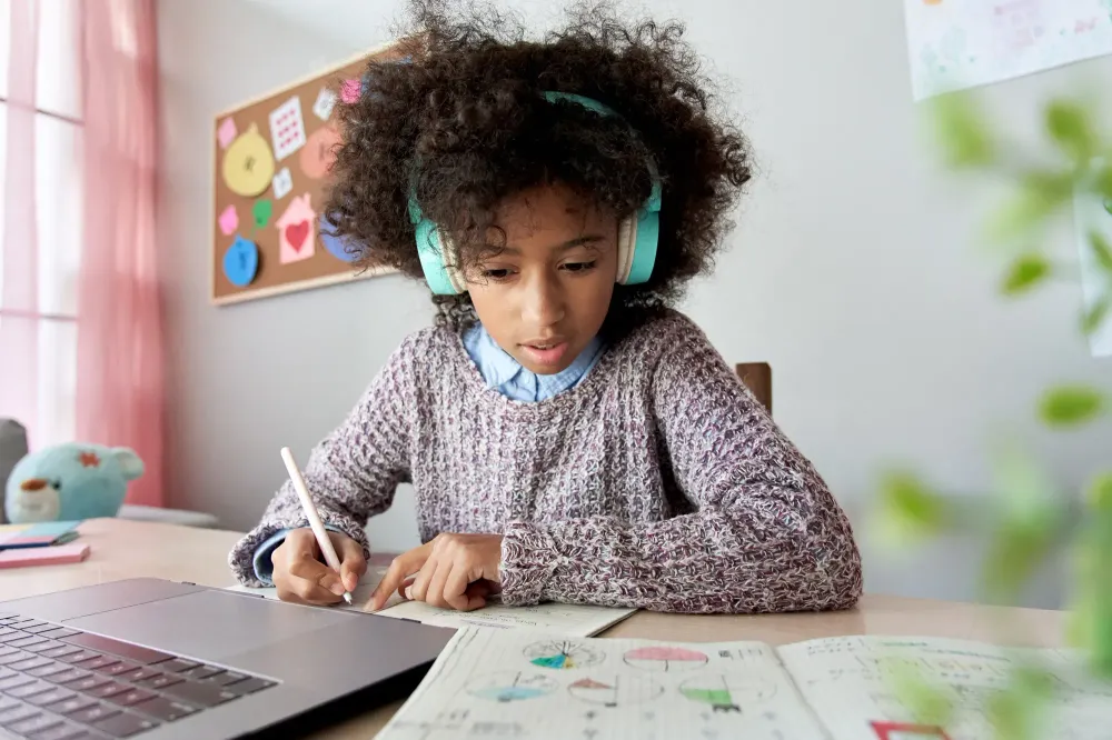 Girl wearing headphones and doing homework