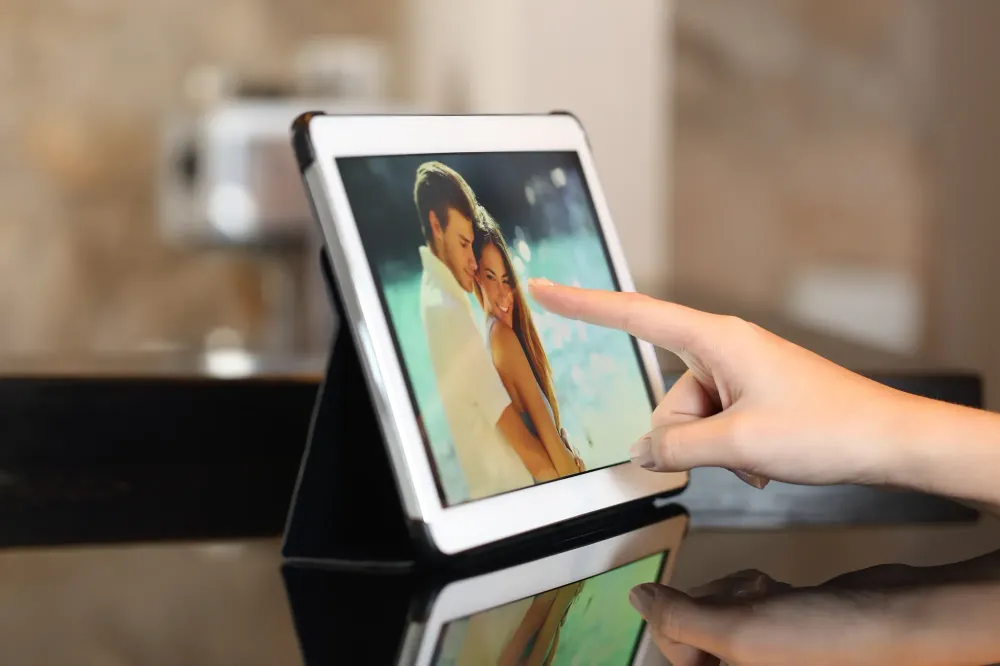 Close-up of a hand scrolling through images on a digital photo frame