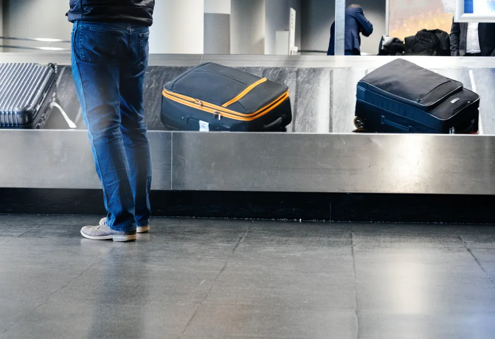 man preparing to take luggage from the conveyor belt
