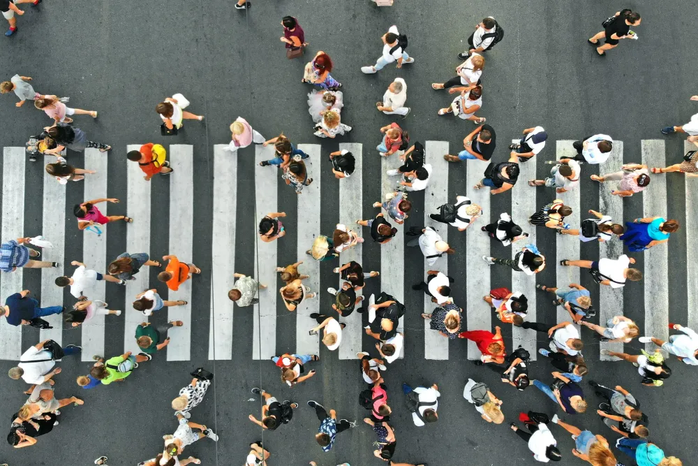 People crowd on pedestrian crosswalk.