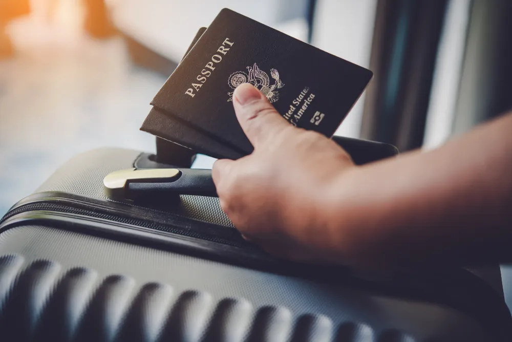 Person holding passports & luggage