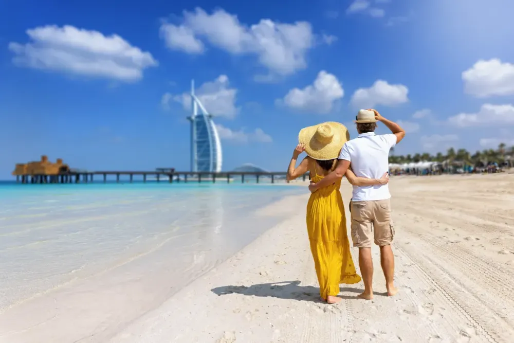 Tourist couple stands embracing on a beach in Dubai