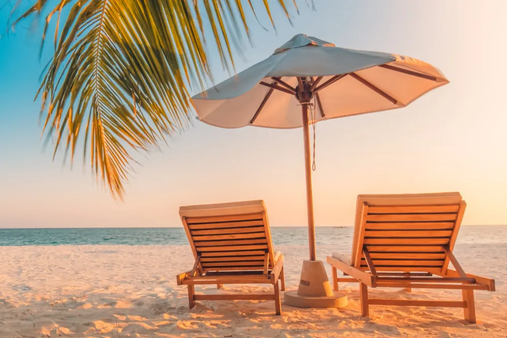Beautiful tropical beach with two sunbeds and a large umbrella