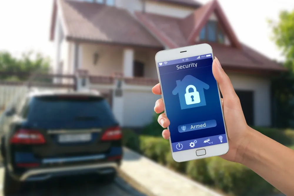Smartphone with home security app in a hand on the building background